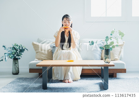 woman drinking coffee in the living room woman drinking coffee in the living room 113617435