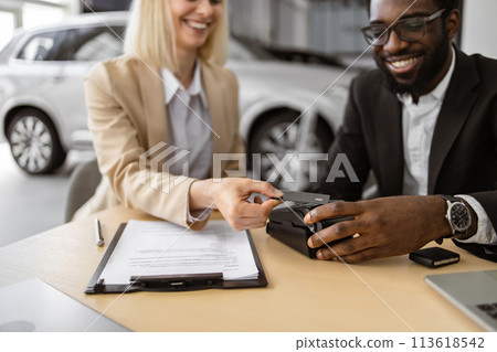 Cropped view of hands of young woman paying with electronic credit card. 113618542