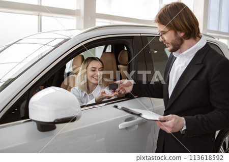 Happy Caucasian female client customer sitting inside new modern SUV car. Happy Caucasian female client customer sitting inside new modern SUV car. 113618592