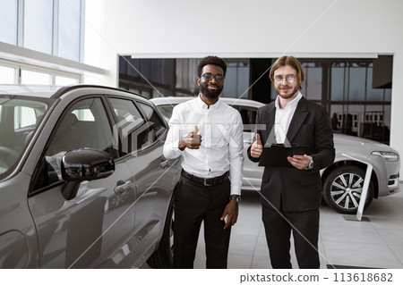 Consultant provides all information about new car using clipboard to male client Consultant provides all information about new car using clipboard to male client 113618682