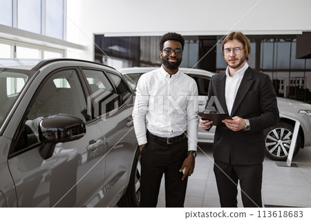 Consultant provides all information about new car using clipboard to male client Consultant provides all information about new car using clipboard to male client 113618683