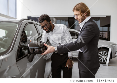 Consultant provides all information about new car using clipboard to male client Consultant provides all information about new car using clipboard to male client 113618684