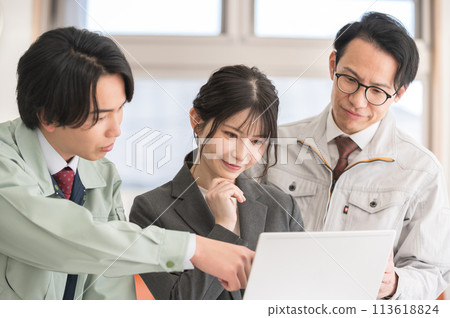 Three male and female engineers having a meeting in an office Three male and female engineers having a meeting in an office 113618824