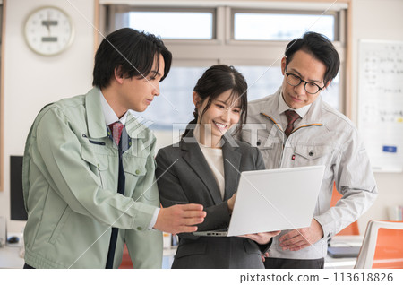 Three male and female engineers having a meeting in an office Three male and female engineers having a meeting in an office 113618826