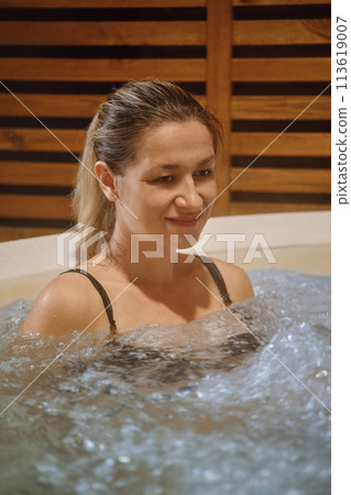 Evening portrait of lovely adult woman in hot tub 113619007