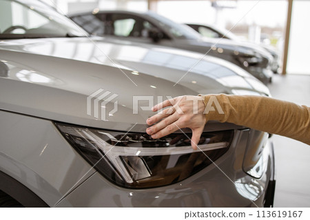 Cropped view of hand of man buyer choosing auto, wants to buy new automobile. Cropped view of hand of man buyer choosing auto, wants to buy new automobile. 113619167