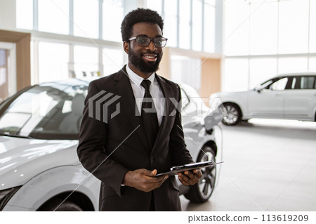 Caucasian man, salesman in suit holding clipboard in bright modern car service. Caucasian man, salesman in suit holding clipboard in bright modern car service. 113619209