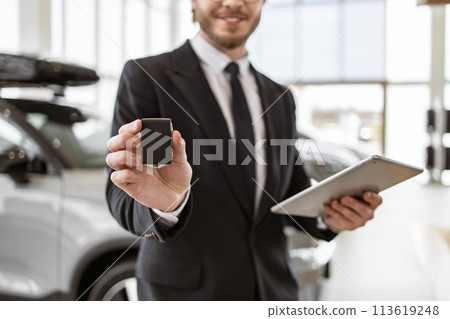 Selective focus on keys in hand of Caucasian male car dealer. Selective focus on keys in hand of Caucasian male car dealer. 113619248