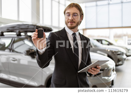 Selective focus on keys in hand of Caucasian male car dealer. Selective focus on keys in hand of Caucasian male car dealer. 113619279