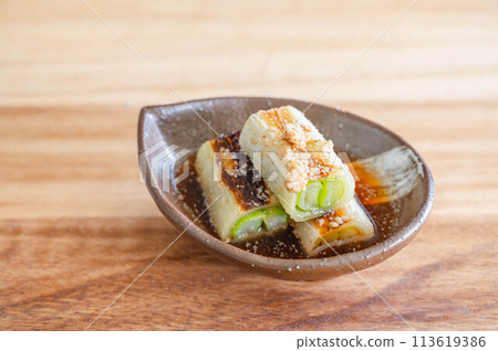 Grilled and marinated green onions 113619386