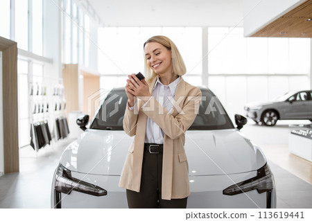 Happy smiling business lady standing near new bought car. Happy smiling business lady standing near new bought car. 113619441