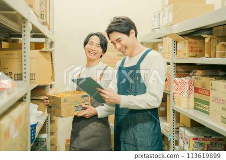 A worker in an apron doing light work in a warehouse A worker in an apron doing light work in a warehouse 113619899