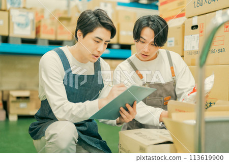 身穿圍裙的工人在倉庫裡做著輕鬆的工作 身穿圍裙的工人在倉庫裡做著輕鬆的工作 113619900