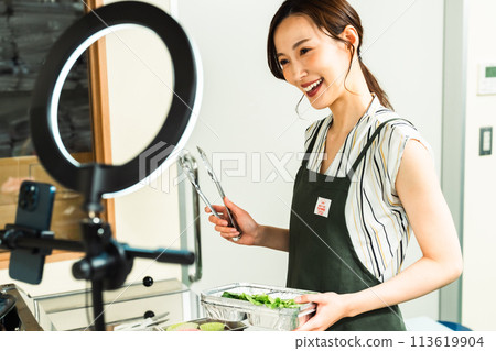 A female influencer cooking in a video broadcast A female influencer cooking in a video broadcast 113619904