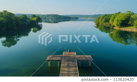 Aerial photography of a lone fisherman waiting patiently at the end of the wooden pier 113620420
