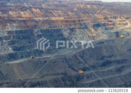 Huge iron ore quarry with working dump trucks and excavators Huge iron ore quarry with working dump trucks and excavators 113620519