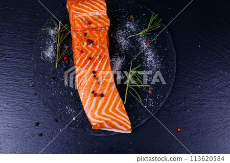 Raw salmon fillet with spices on black slate. Top view Raw salmon fillet with spices on black slate. Top view 113620584