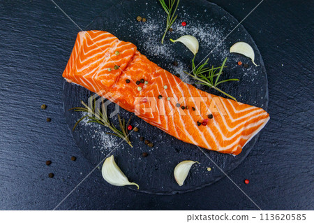 Raw salmon fillet with spices on black slate. Top view Raw salmon fillet with spices on black slate. Top view 113620585