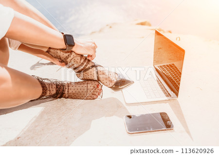 Woman sea laptop. Business woman in yellow hat freelancer with laptop working over blue sea beach. Girl relieves stress from work. Freelance, digital nomad, travel and holidays concept Woman sea laptop. Business woman in yellow hat freelancer with laptop working over blue sea beach. Girl relieves stress from work. Freelance, digital nomad, travel and holidays concept 113620926
