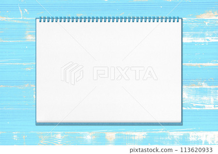 A blue wooden deck with a shabby finish and a page from a folded sketchbook 113620933