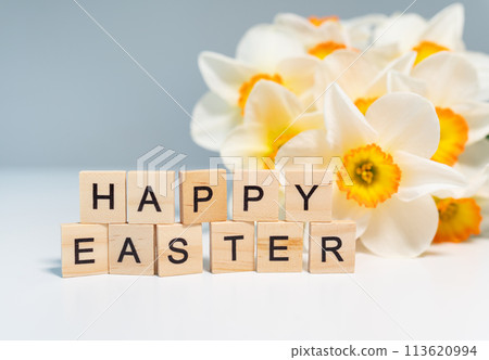 A bouquet of white daffodils with the word HAPPY EASTER spelled out in wooden letter tiles. A bouquet of white daffodils with the word HAPPY EASTER spelled out in wooden letter tiles. 113620994