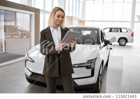 Professional salesperson working in bright and spacious car dealership. Professional salesperson working in bright and spacious car dealership. 113621483