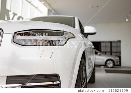 Front part of brand new modern white car, parked at showroom. 113621509