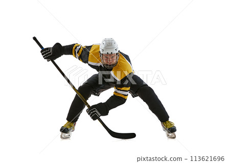Highly concentrated man, hockey player wearing helmet and protective uniform standing in position with stick during game isolated on white background 113621696