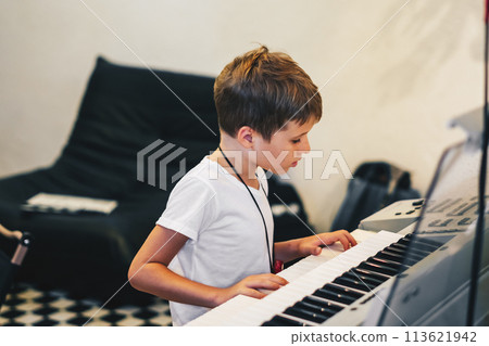 Young boy Portrait sitting at digital piano Playing keyboard focused kid activity indoors press on Key learning to play music room Hobby Young boy Portrait sitting at digital piano Playing keyboard focused kid activity indoors press on Key learning to play music room Hobby 113621942