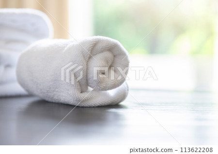 Roll up of white towels on table with copy space on blurred room background. For product display montage. 113622208