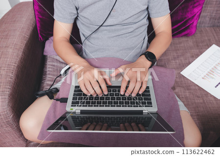 A man in casual wear using laptop while he is working at home office. A man in casual wear using laptop while he is working at home office. 113622462