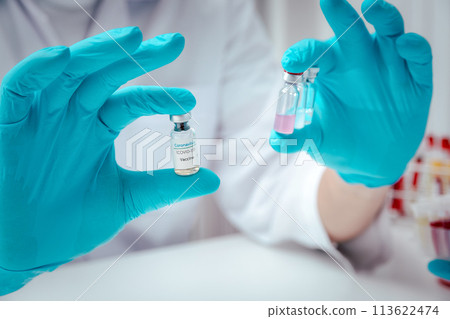 Researcher holding vaccine sample in the laboratory. Researcher is inventing vaccines to treat COVID-19 virus. 113622474
