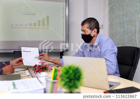 Businessmen wearing protective masks discussing and work together in meeting room. Social distance practice prevent coronavirus COVID-19. 113622667