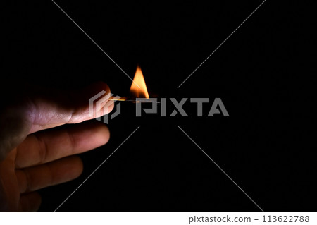 burning match in the fingers of a man close-up on a black background burning match in the fingers of a man close-up on a black background 113622788