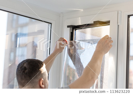 Installation of tinted film. Ultraviolet and energy afficiency concept. 113623220