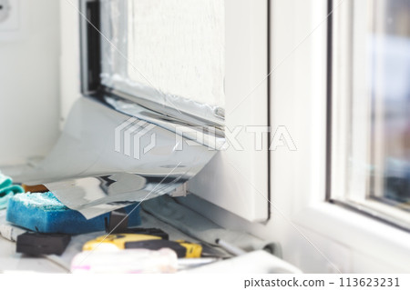 Installation of tinted film. Ultraviolet and energy afficiency concept. Installation of tinted film. Ultraviolet and energy afficiency concept. 113623231