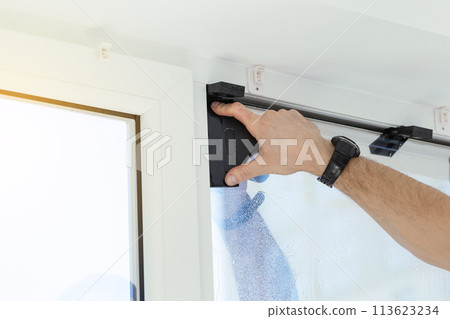 Installation of tinted film. Ultraviolet and energy afficiency concept. Installation of tinted film. Ultraviolet and energy afficiency concept. 113623234