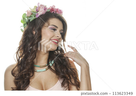 Smiling young model with long curly hair, makeup and perfect healthy skin, floral blossom portrait. Smiling young model with long curly hair, makeup and perfect healthy skin, floral blossom portrait. 113623349