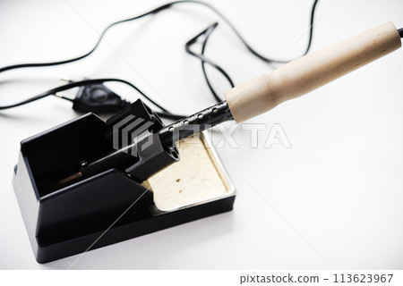 Soldering iron with a wooden handle in the holder. A soldering iron stand. 113623967