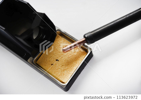 Soldering iron with a wooden handle in the holder. A soldering iron stand. Soldering iron with a wooden handle in the holder. A soldering iron stand. 113623972