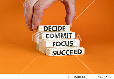 Decide commit focus succeed symbol. Concept word Decide Commit Focus Succeed on wooden block. Beautiful orange background. Businessman hand. Business decide commit focus succeed concept. Copy space. 113624379