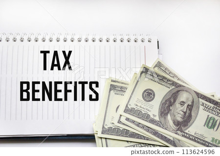 The word tax breaks on a notepad next to dollars. Business and taxation concept. The word tax breaks on a notepad next to dollars. Business and taxation concept. 113624596