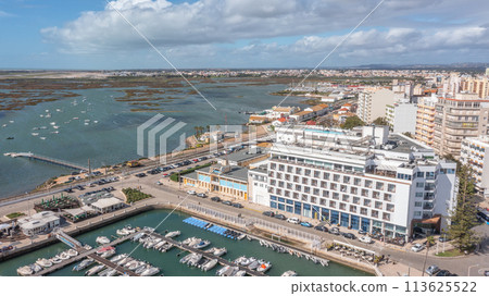 Panoramic aerial view taken by drone of the coastal town of Faro overlooking the Ria Formosa. On a bright sunny day. Panoramic aerial view taken by drone of the coastal town of Faro overlooking the Ria Formosa. On a bright sunny day. 113625522