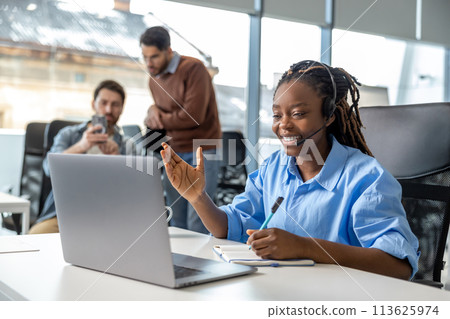 Business woman in wireless headset has video conference calling on laptop Business woman in wireless headset has video conference calling on laptop 113625974