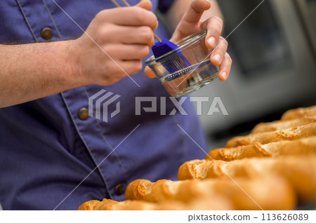 Unrecognizable man baker baking French baguette bread 113626089