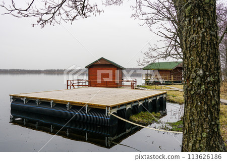 A new empty wooden platform on pontoons in the lake for the creation of a holiday house on the water 113626186