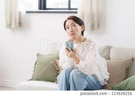 一位 30 多歲的女性擔心看智慧型手機 一位 30 多歲的女性擔心看智慧型手機 113626258