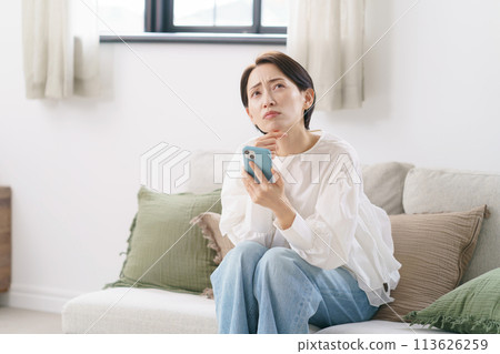 一位 30 多歲的女性擔心看智慧型手機 一位 30 多歲的女性擔心看智慧型手機 113626259