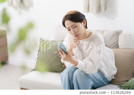 A woman in her 30s worried about her smartphone 113626260