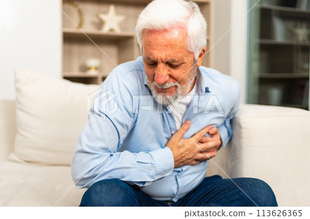 Pain on heart, heart attack. Unhappy middle aged senior man suffering from chest pain heart attack problems with health at home. Mature old senior grandfather touching chest experiencing infarction 113626365